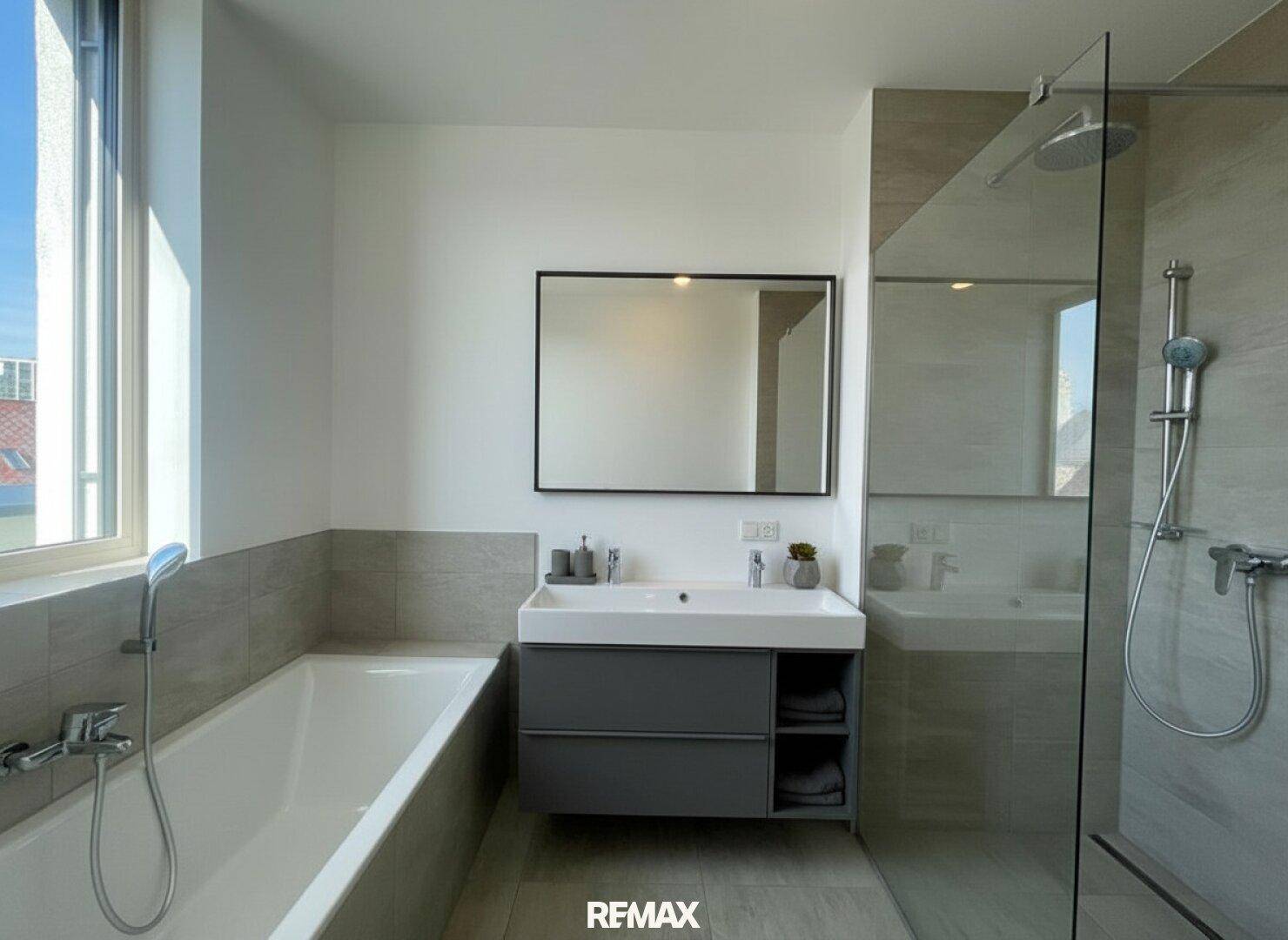 Modernes Badezimmer mit Badewanne, begehbarer Dusche, Einzelwaschbecken und Fenster für Tageslicht.