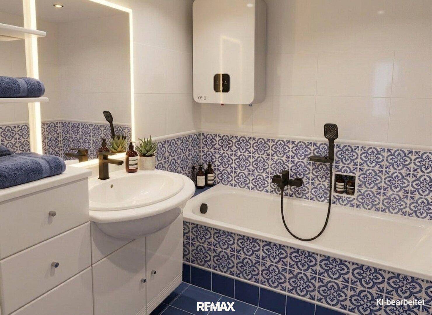 Modernisiertes Badezimmer mit blauen Fliesen, Badewanne und neuem Waschbecken.