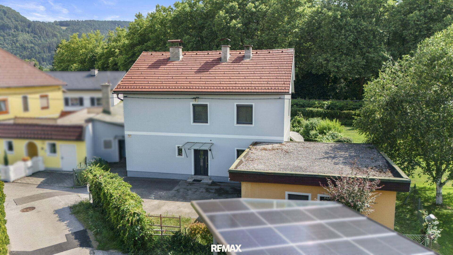 Rückansicht des Hauses mit Garten und angrenzendem Nebengebäude.