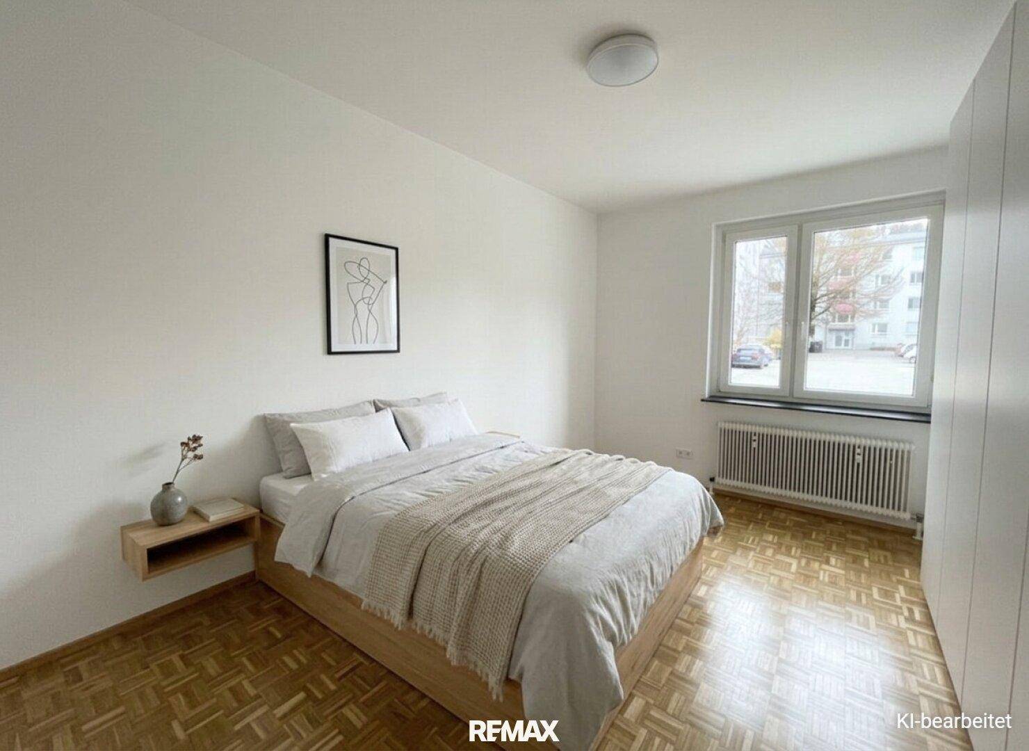 Schlichtes Schlafzimmer mit Doppelbett, Parkettboden und integrierten weißen Kleiderschränken.