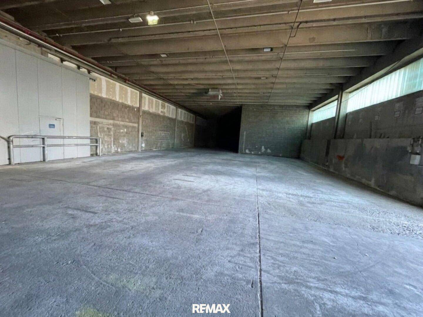 Großer, leerer Lagerraum mit hohen Decken und Betonboden, ideal für industrielle Nutzung.