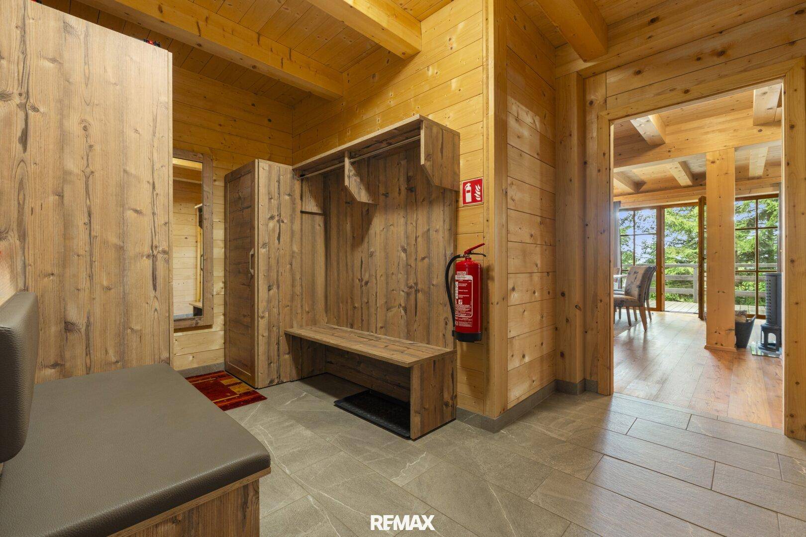 Gemütlicher Eingangsbereich mit Holzvertäfelung, Garderobe und Fliesenboden.