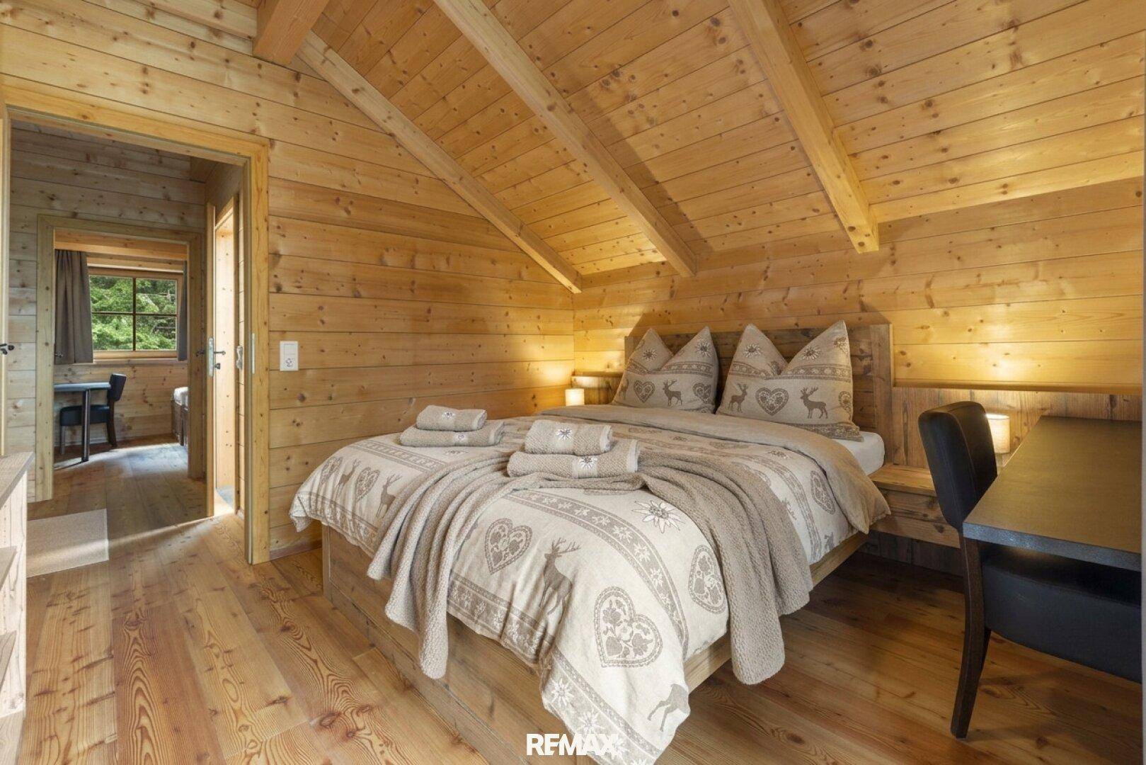 Komfortables Schlafzimmer mit Doppelbett, Holzboden und traditioneller Bettwäsche.
