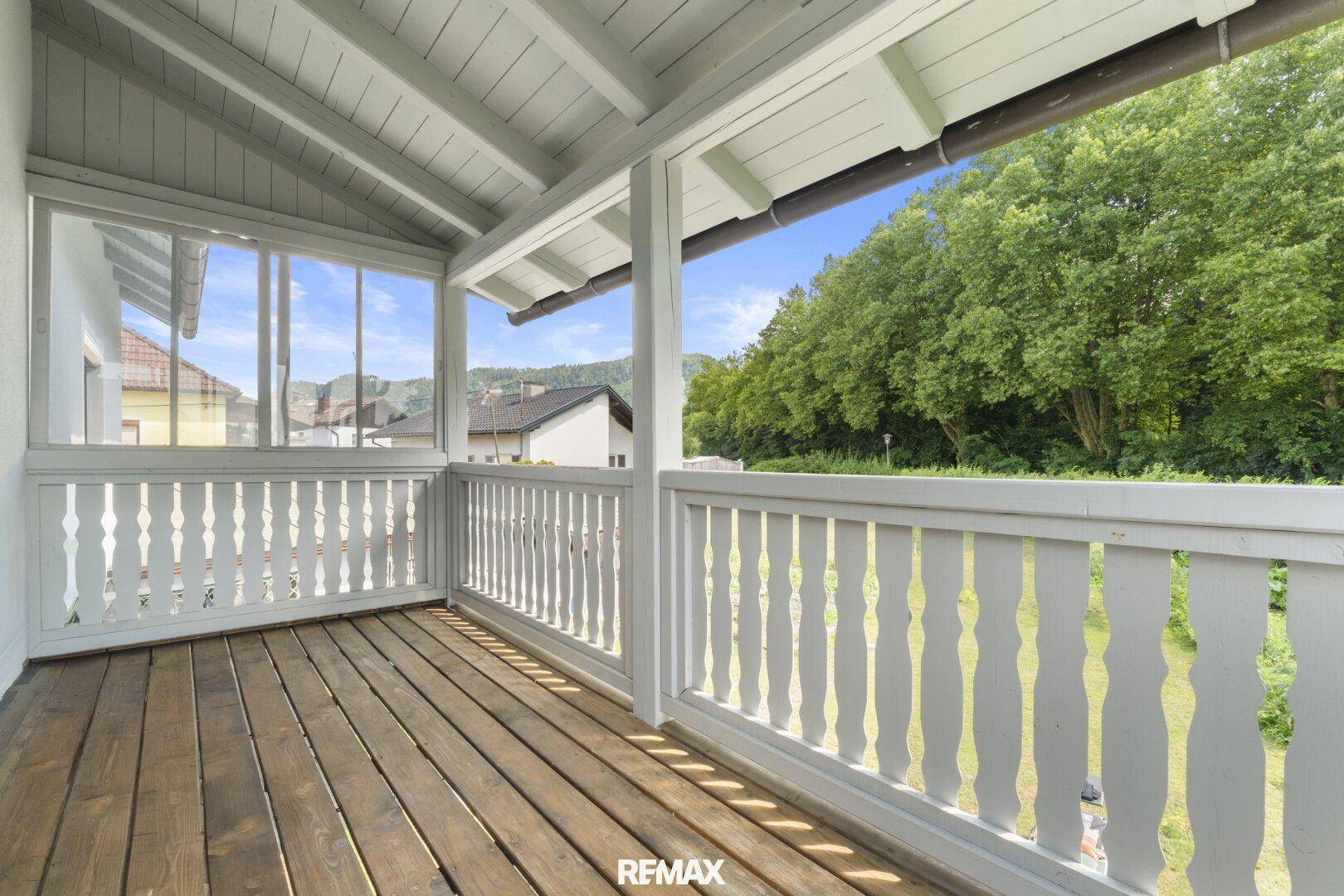 Heller Balkon mit Holzboden und schöner Aussicht auf die Umgebung.