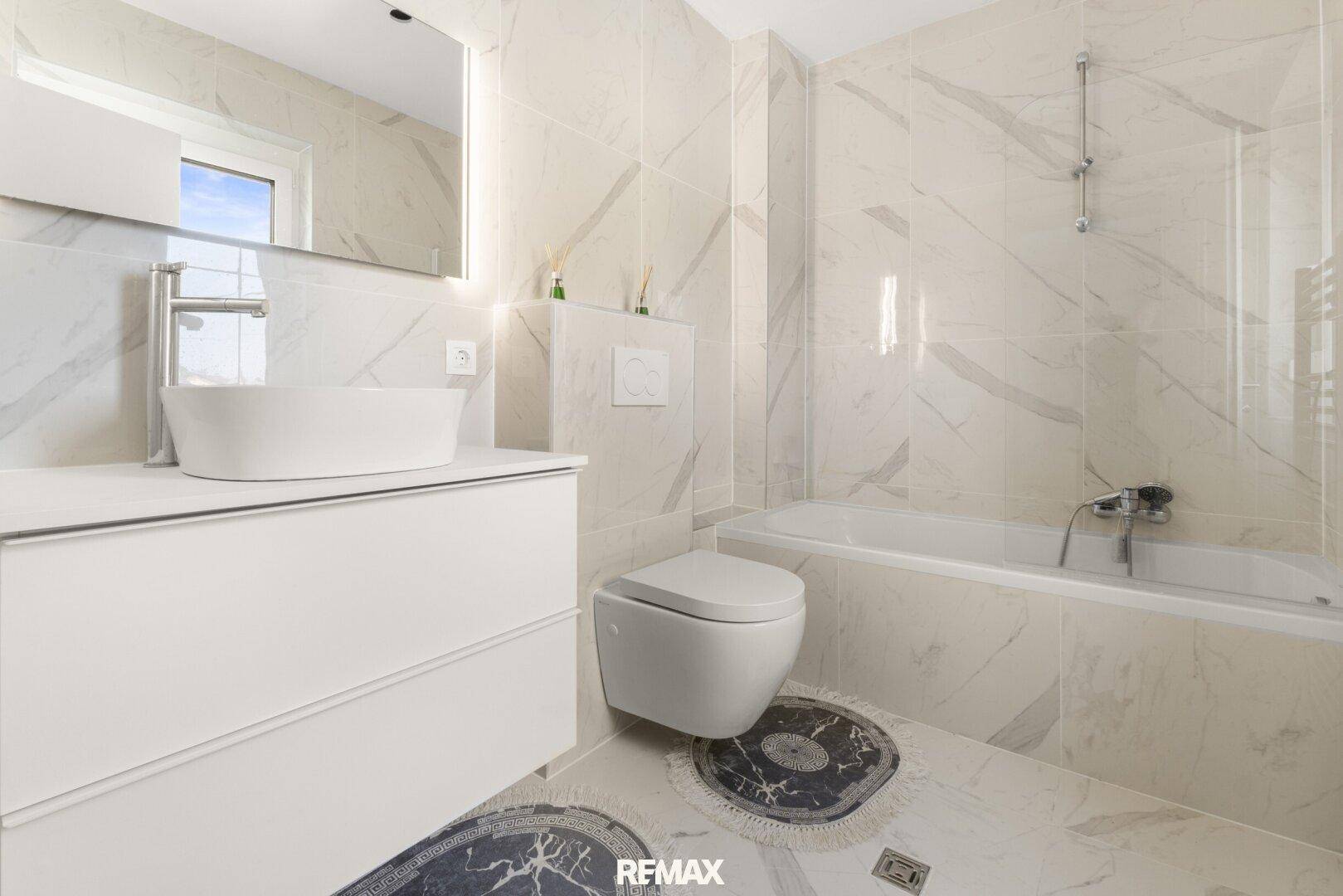 Modernes Badezimmer mit Badewanne, Wand-WC und Einzelwaschbecken.