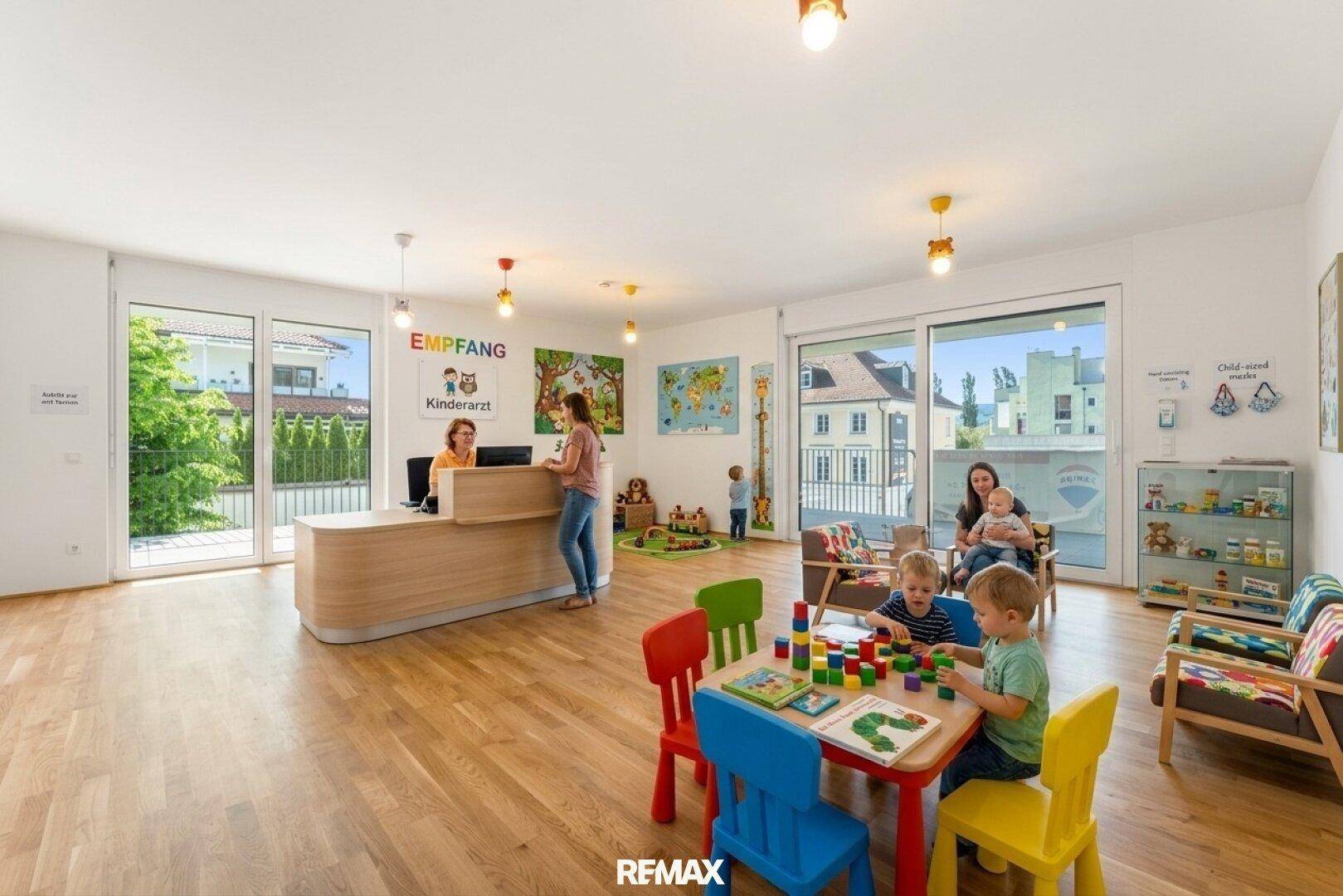 Freundlicher Empfangsbereich einer Kinderarztpraxis mit Spielbereich, Holzboden und großen Fenstern.