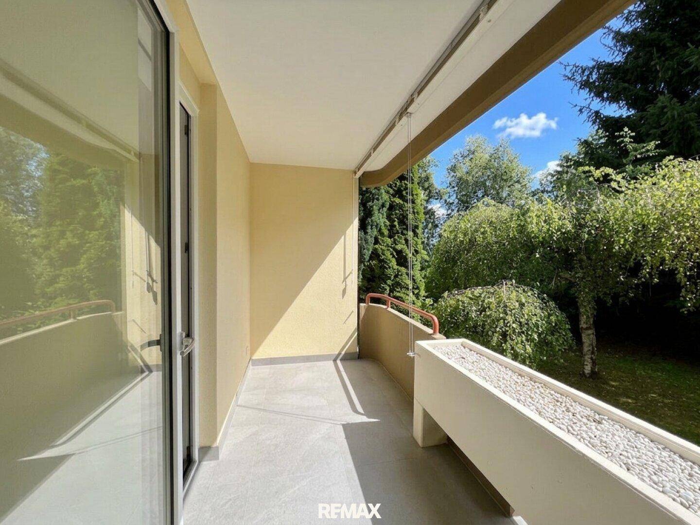 Heller, unmöblierter Balkon mit Fliesenboden und einem Blumenkasten mit Kies.