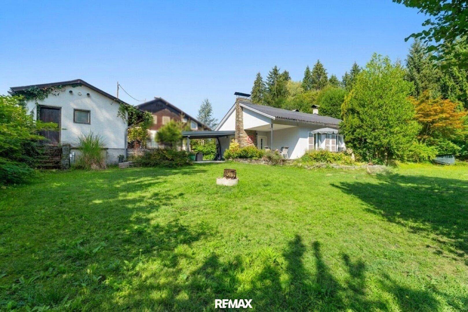 Großer, gepflegter Garten mit weitläufiger Rasenfläche und Blick auf das Haus.