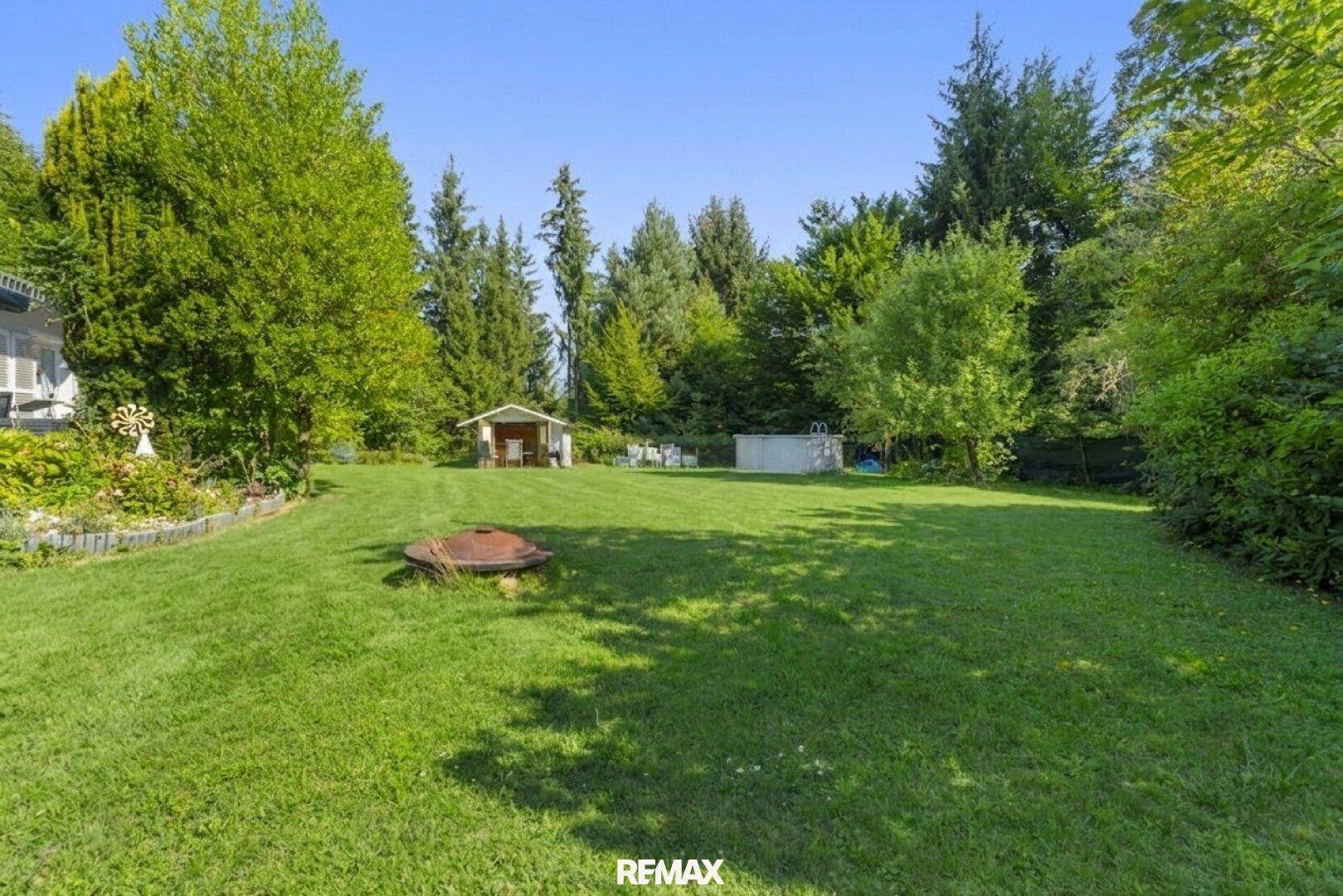 Weitläufiger Garten mit Rasenfläche, kleinem Pool und Gartenhaus, ideal für Freizeit.