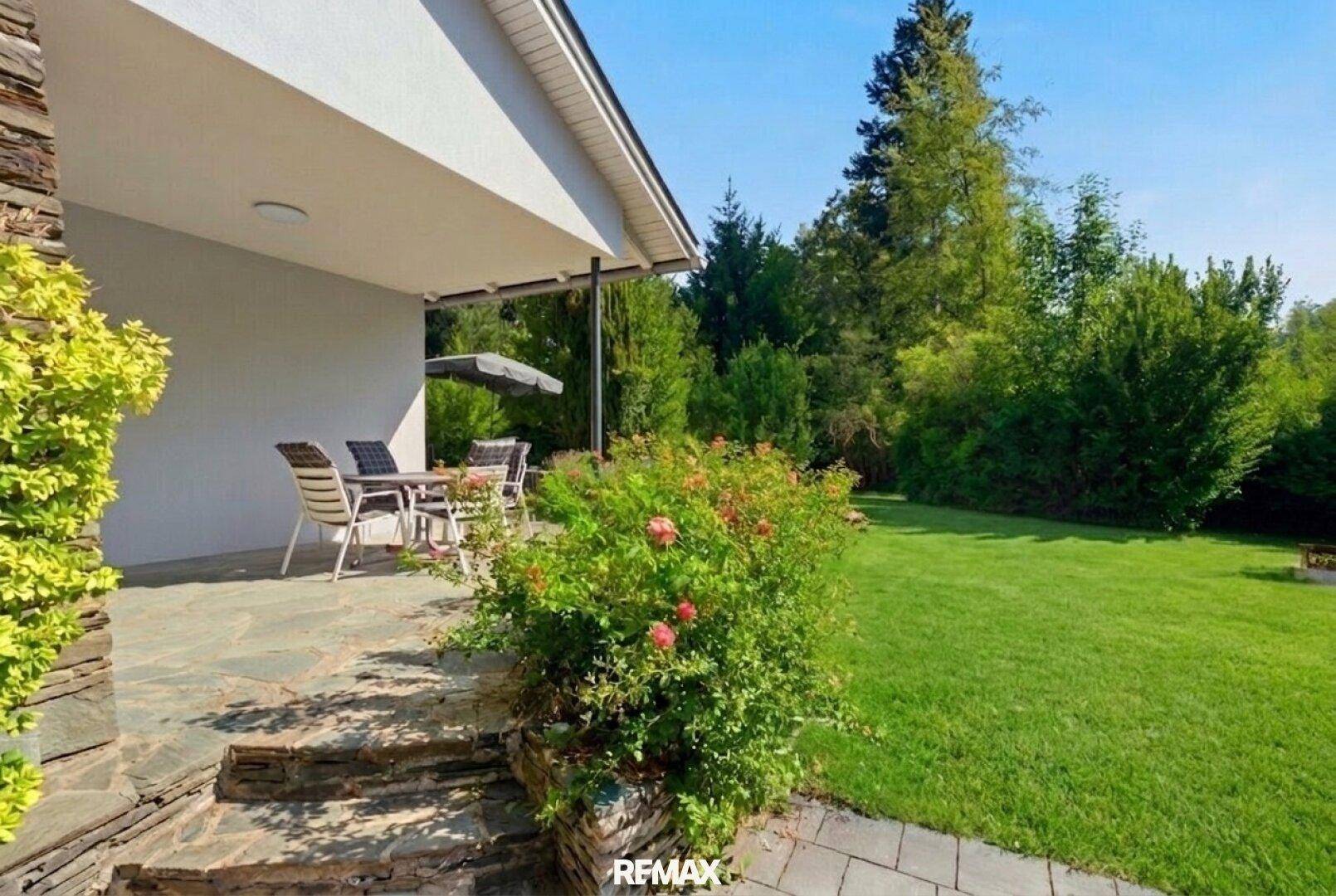 Gemütliche Terrasse mit Gartenmöbeln und direktem Zugang zum gepflegten Rasen.
