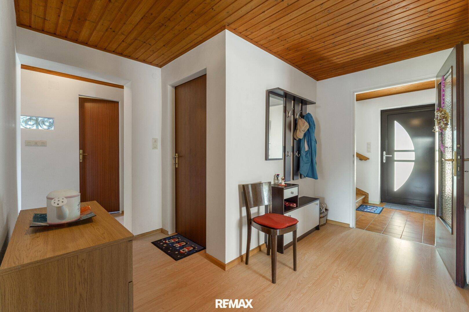 Heller Flur mit Holzdecke und Garderobe, verbindet die verschiedenen Wohnbereiche.
