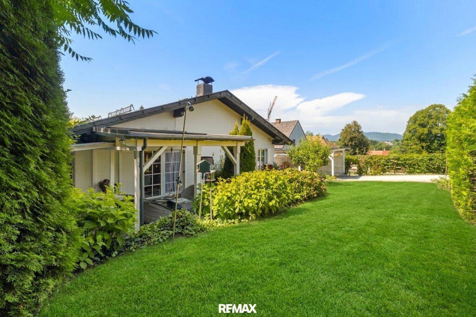 Rückansicht des Hauses mit weitläufigem, gepflegtem Garten und üppiger Bepflanzung.