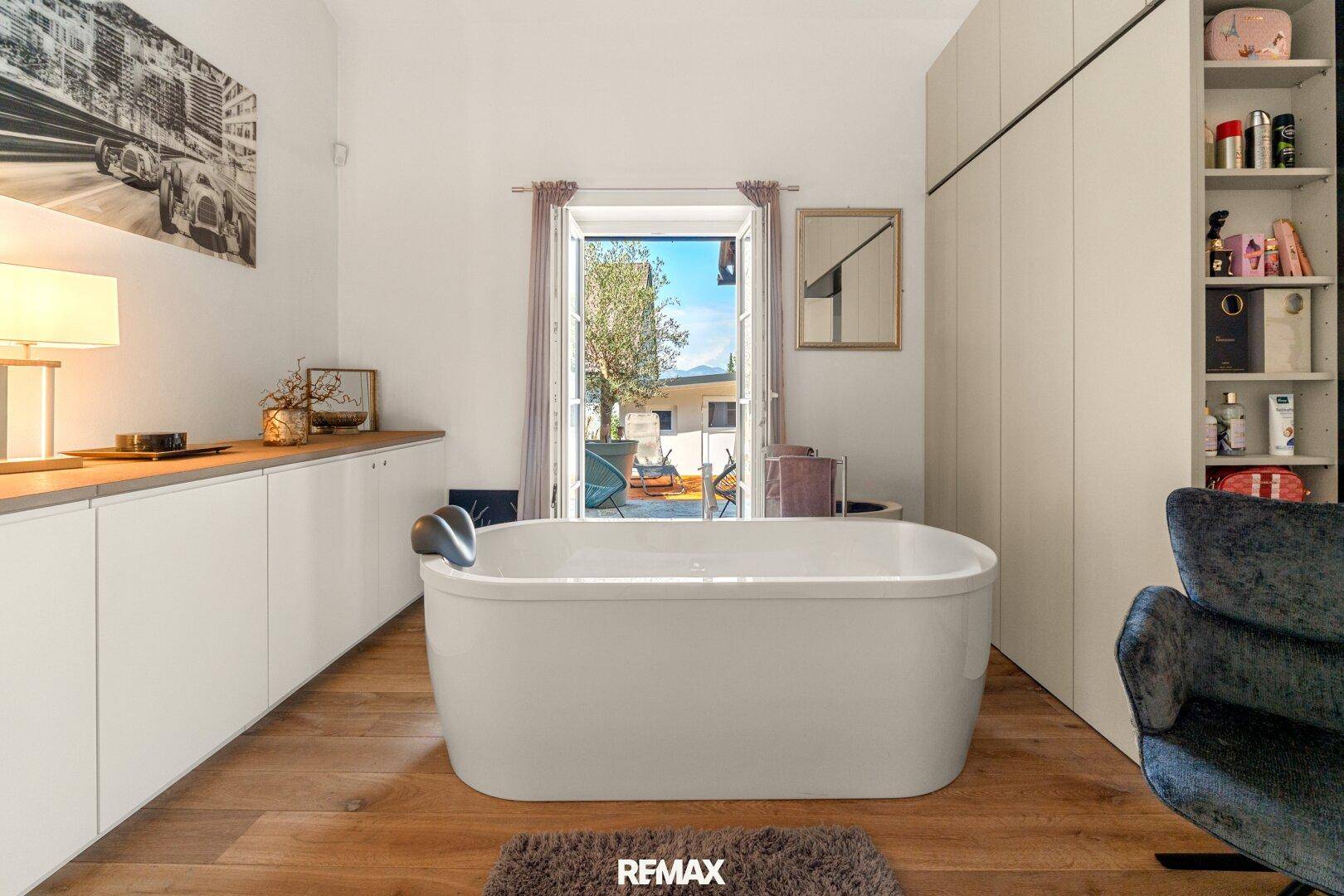 Modernes Badezimmer mit freistehender Badewanne und Zugang zu einem Außenbereich.
