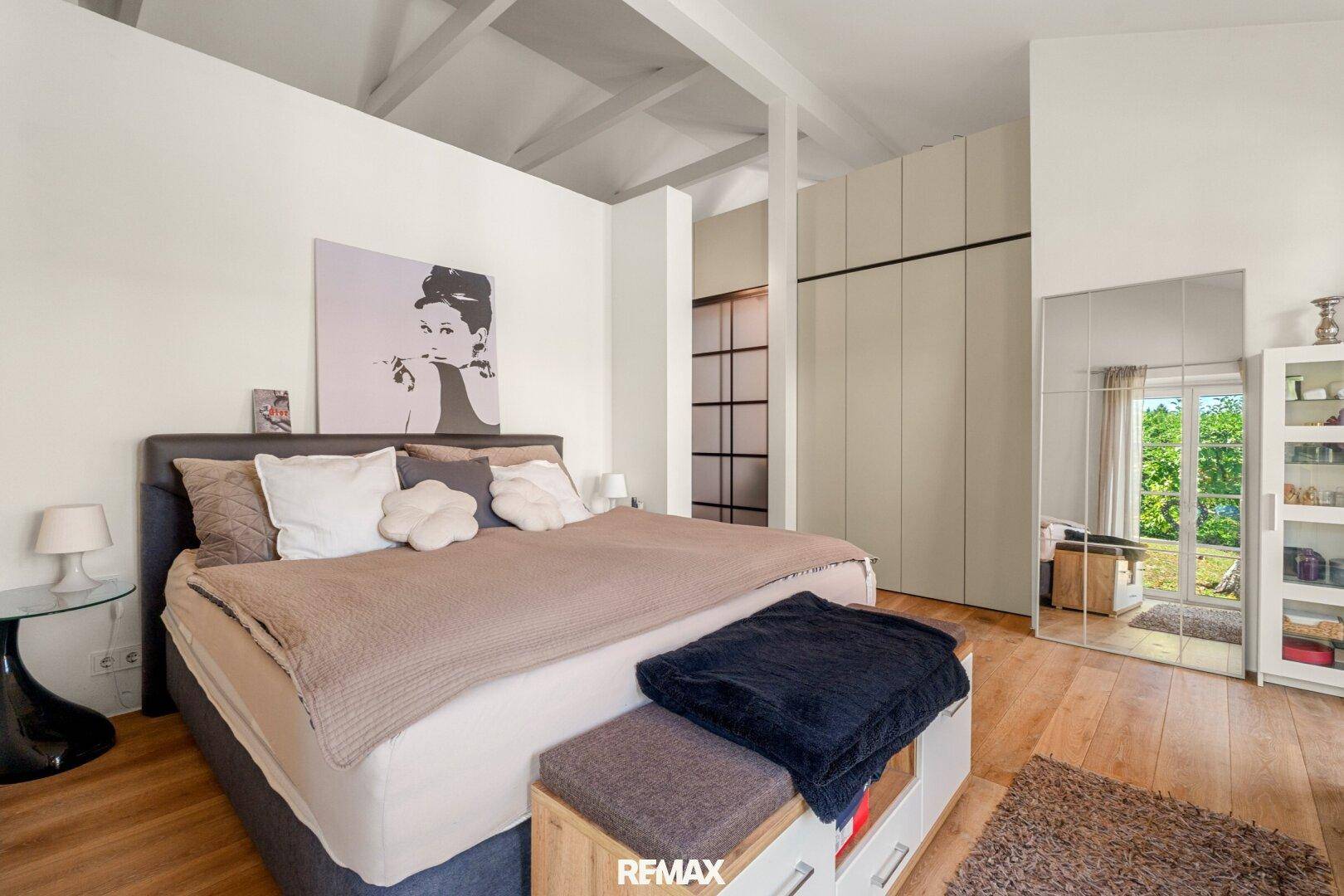 Geräumiges Schlafzimmer mit Holzboden, hohen Decken und Einbauschränken.