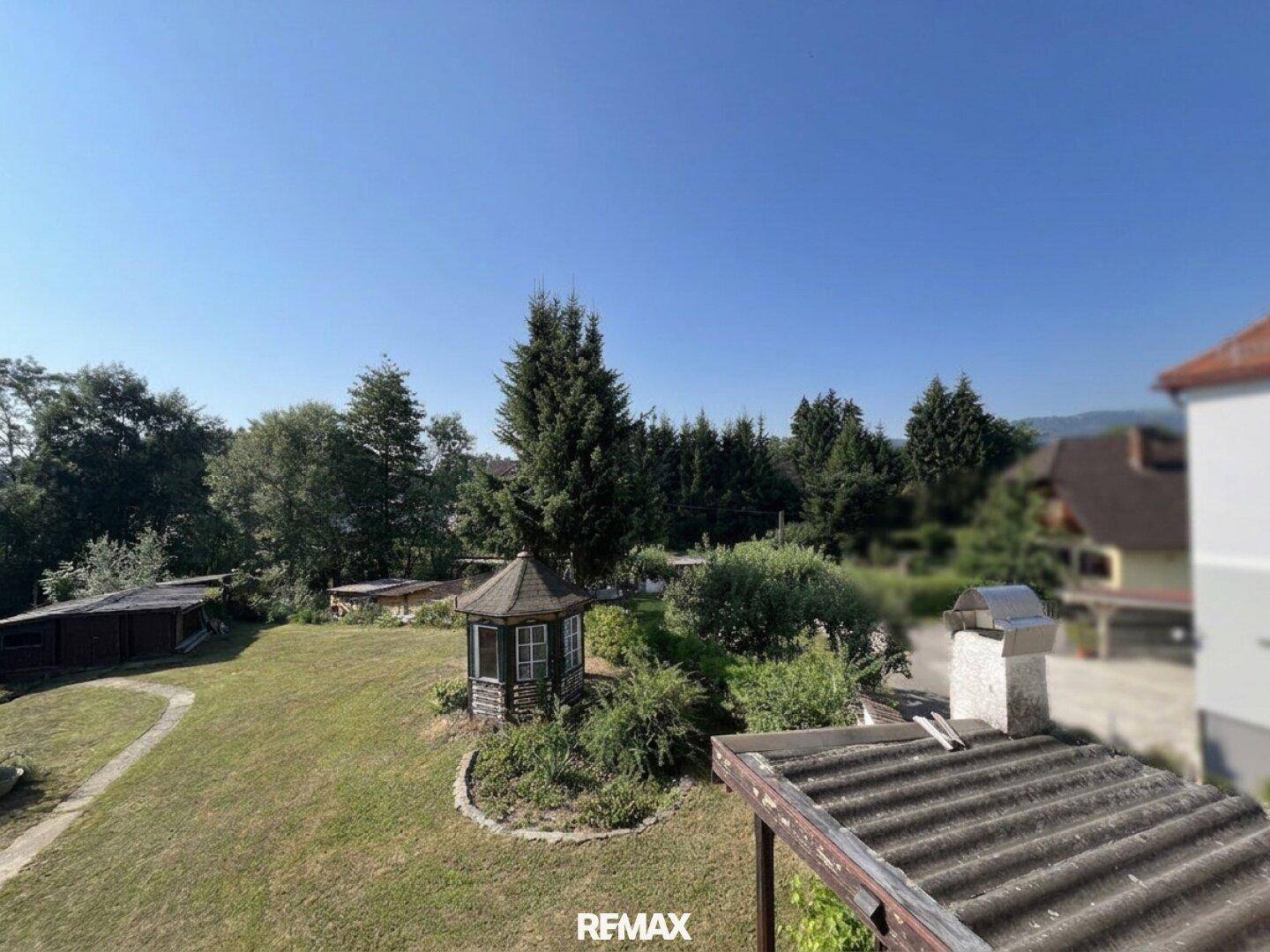 Panoramablick auf den Garten mit Pavillon und üppiger Vegetation von erhöhter Position.