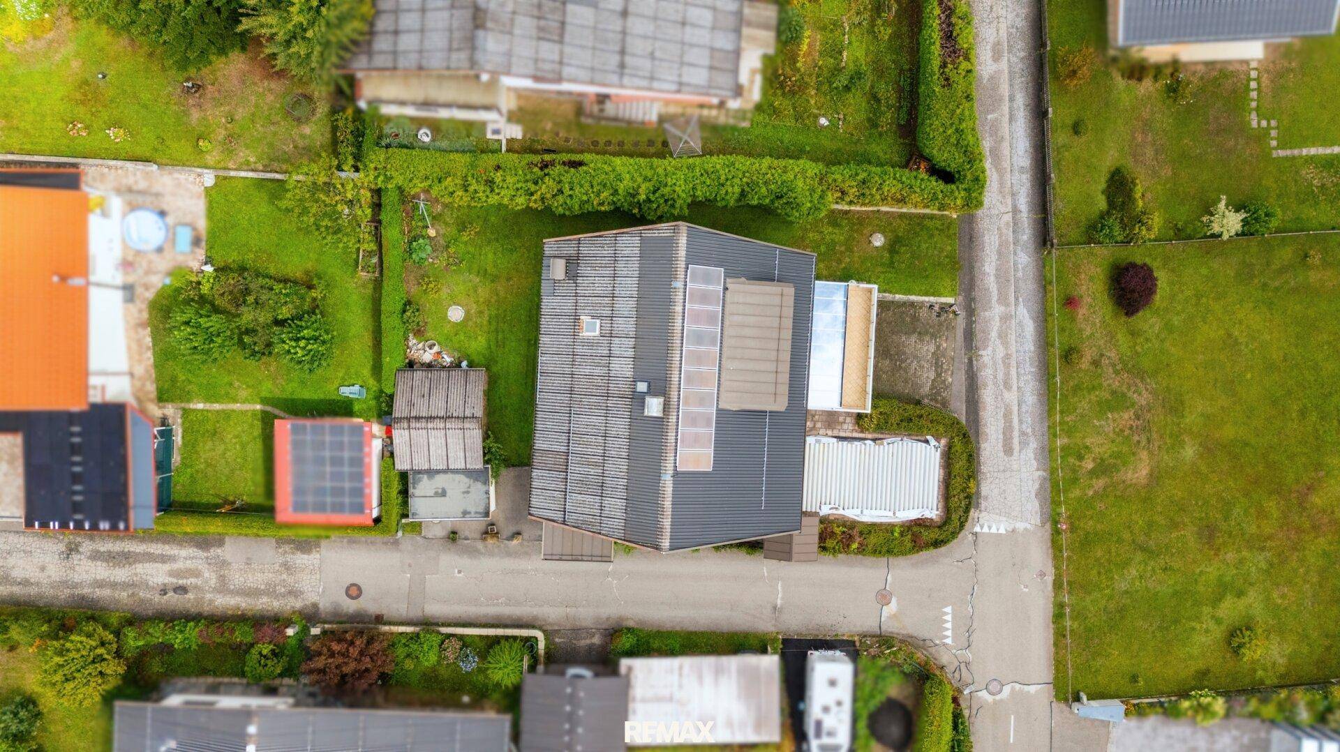 Dachansicht des Hauses mit Solaranlage und umliegenden Gärten.
