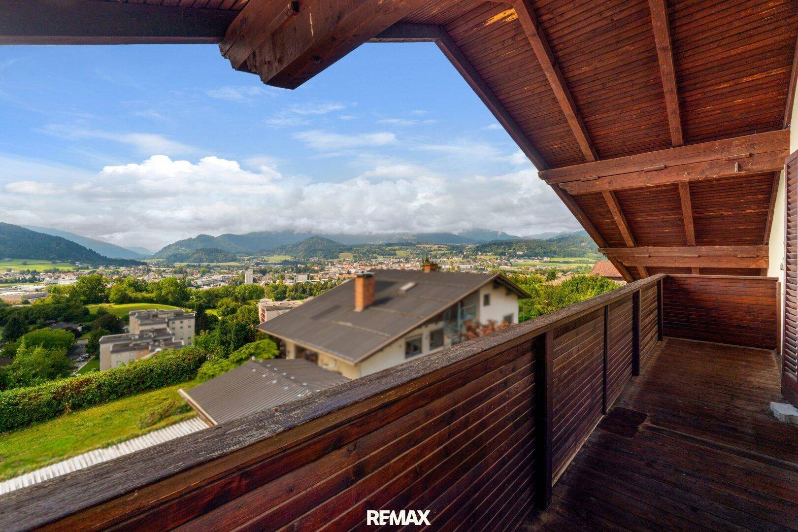 Holzbalkon mit schöner Aussicht auf die Stadt und die Berglandschaft.