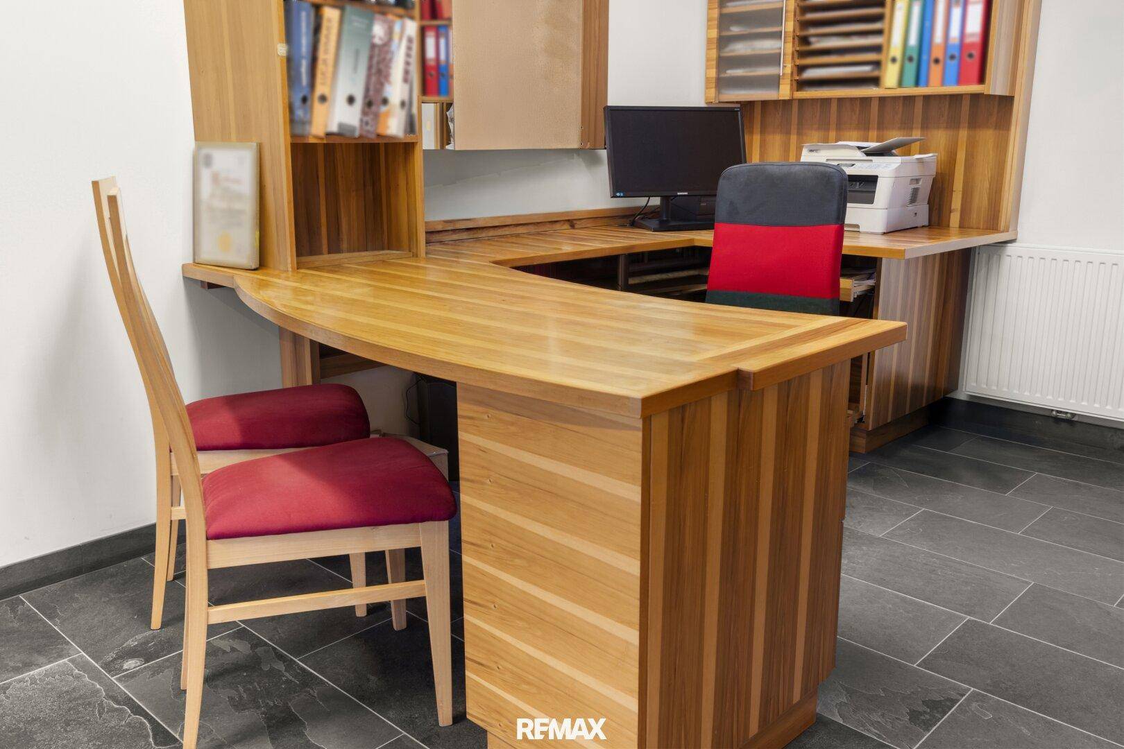 Funktioneller Büroraum mit großem Holzschreibtisch und Stauraum, ideal für Verwaltungsaufgaben.
