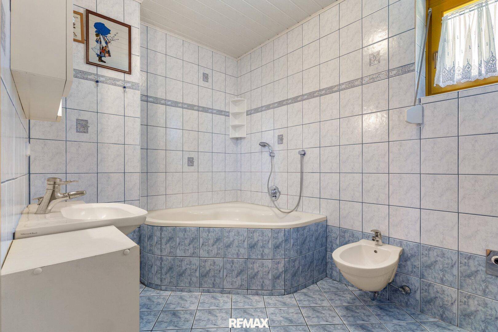 Badezimmer mit Eckbadewanne, Bidet und blauen Fliesen im traditionellen Stil.