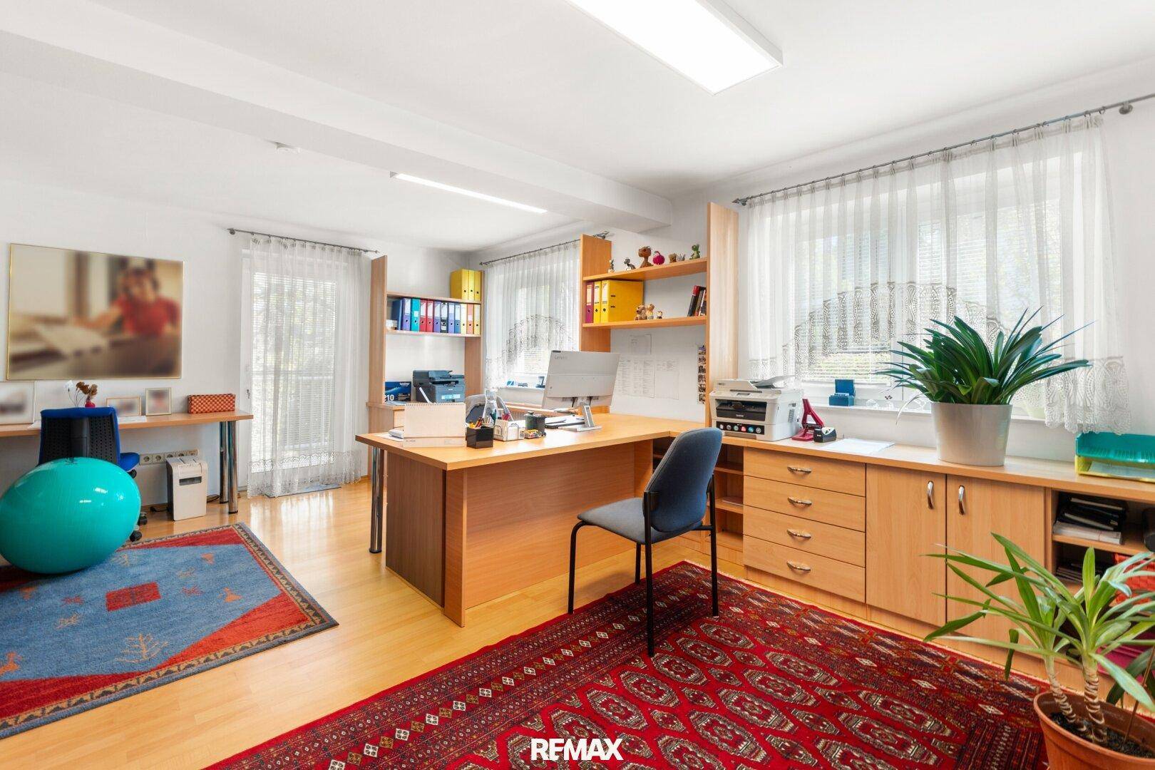 Großes Büro mit mehreren Arbeitsplätzen, Fenstern und Teppichen, bietet viel Tageslicht.