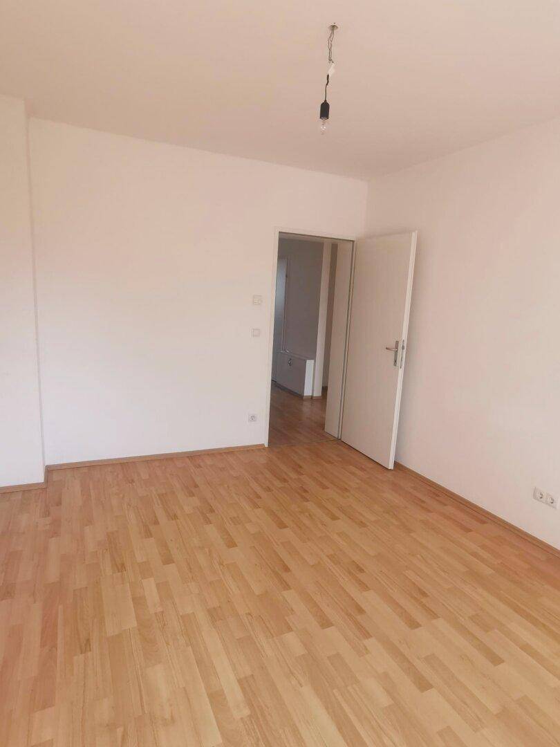 Helles Wohnzimmer mit Holzboden und weißen Wänden, bietet viel Gestaltungsfreiheit.
