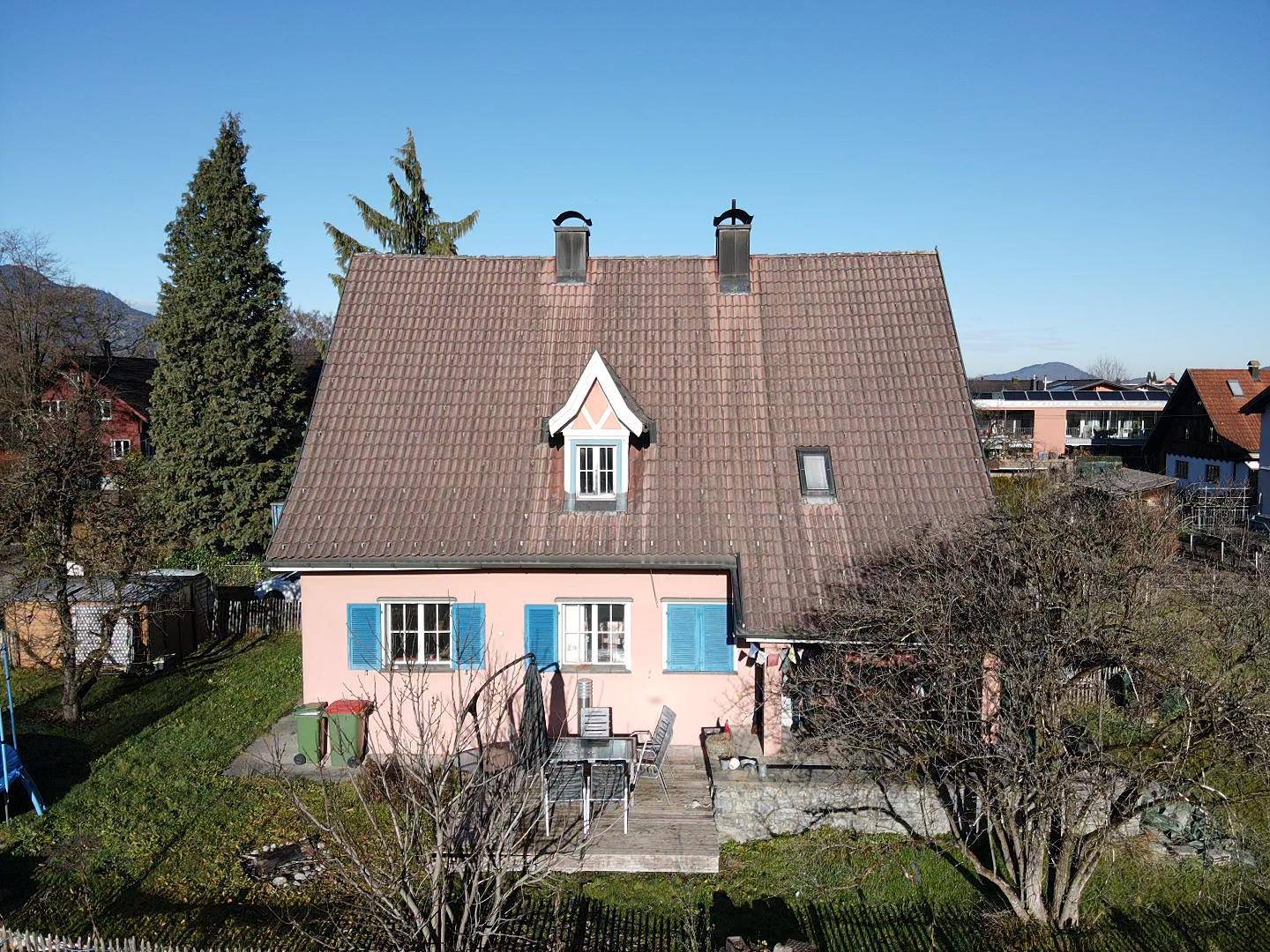 Vorderansicht des Hauses mit Terrasse, Gartenmöbeln und traditionellem Satteldach.