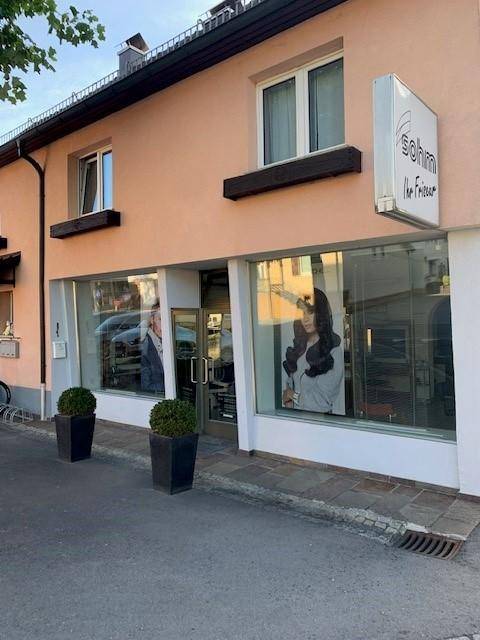 Fassade des Geschäftsgebäudes mit großen Schaufenstern und dem Eingangsbereich des Friseursalons.