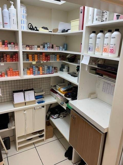 Weiterer Blick in den Lagerraum mit umfangreichen Produktregalen und einer kleinen Arbeitsfläche.