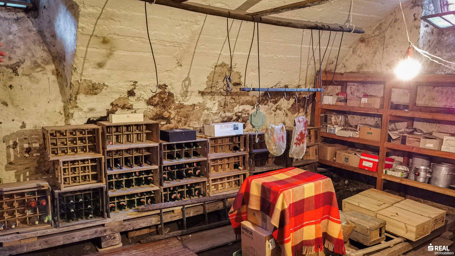 Rustikaler Weinkeller mit Holzregalen, Weinflaschen und Lagerflächen.