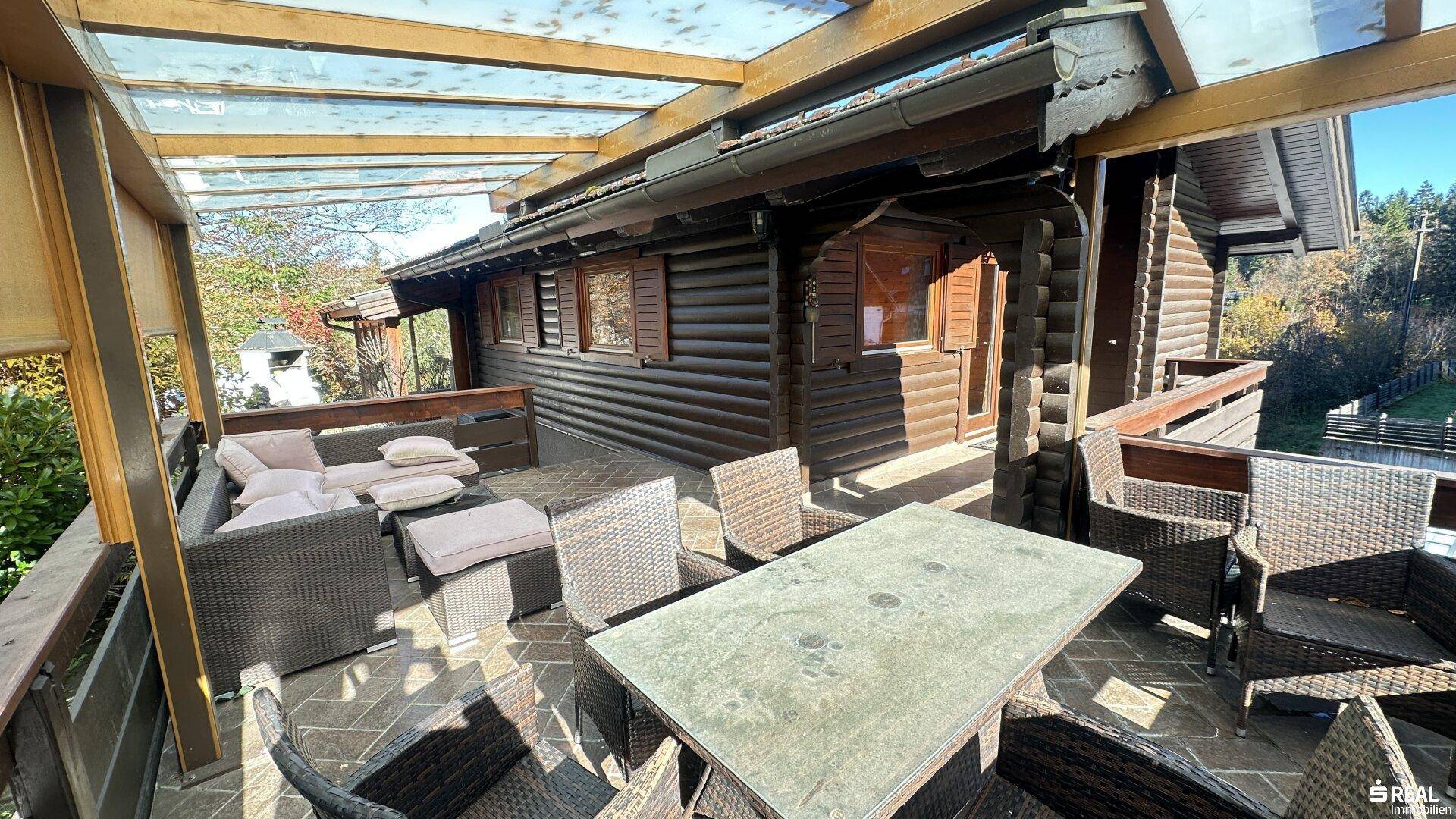 Geräumige, überdachte Terrasse mit Essbereich und Lounge-Möbeln für entspannte Stunden im Freien.
