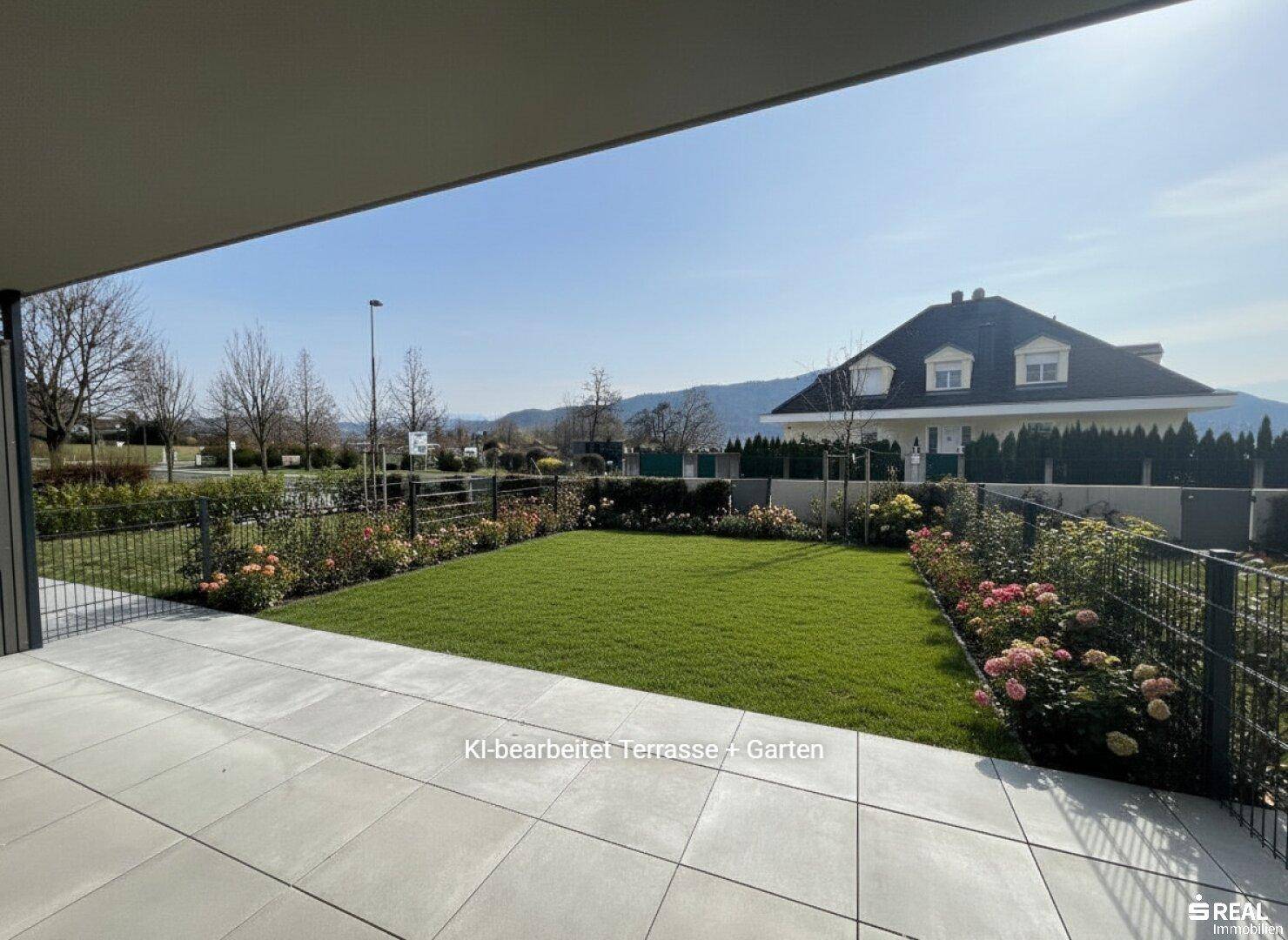 Großzügige Terrasse mit Rasenfläche, Blumenbeeten und weitem Blick ins Grüne.