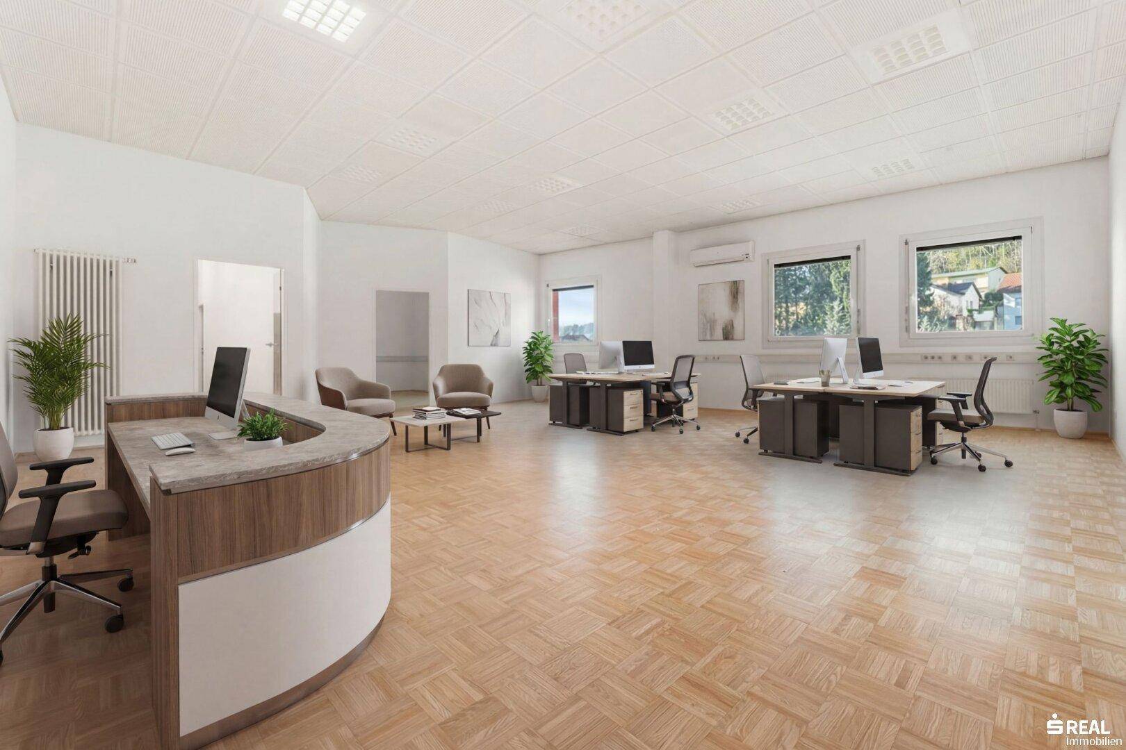Geräumiger, offener Bürobereich mit Empfangstheke, mehreren Arbeitsplätzen und einer Sitzecke.