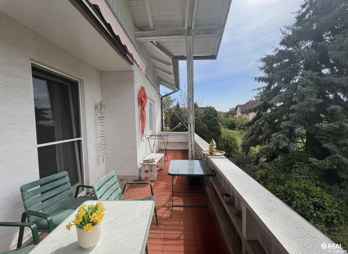 Gemütlicher Balkon mit roten Fliesen und Gartenmöbeln, ideal für entspannte Stunden im Freien mit Weitblick.