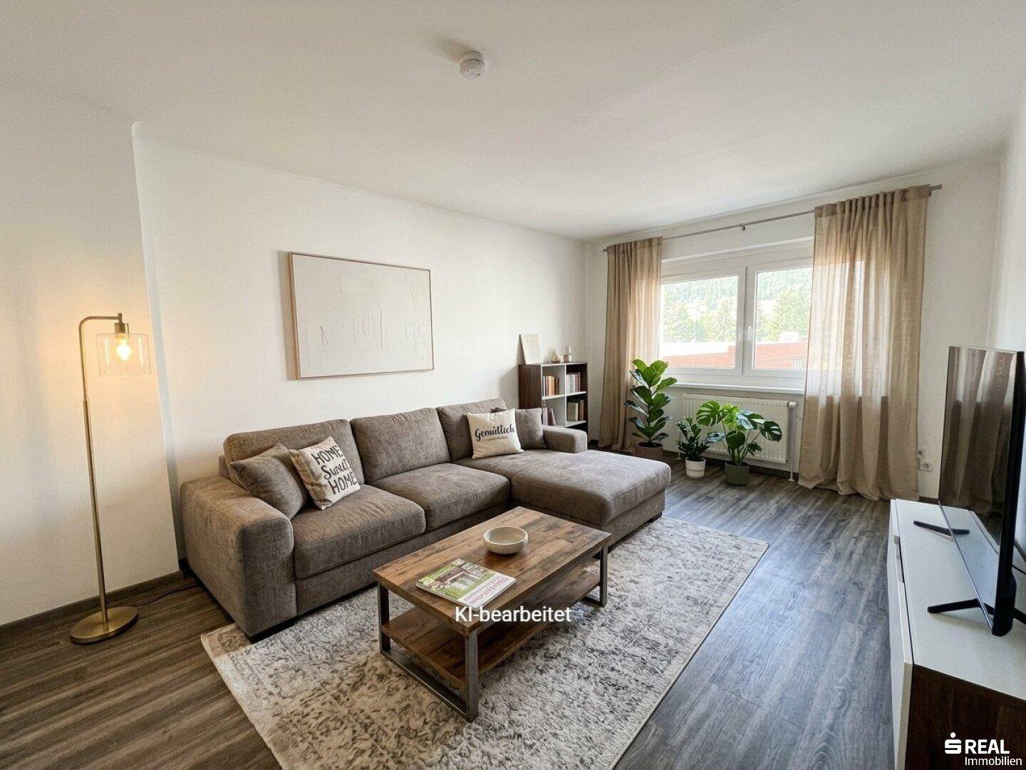 Gemütliches Wohnzimmer mit Sofa, Couchtisch und Blick auf die Umgebung.