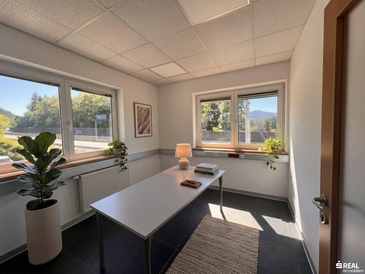 Helles Büro mit einem einfachen Schreibtisch, natürlichem Licht und Blick auf die umliegende Landschaft.