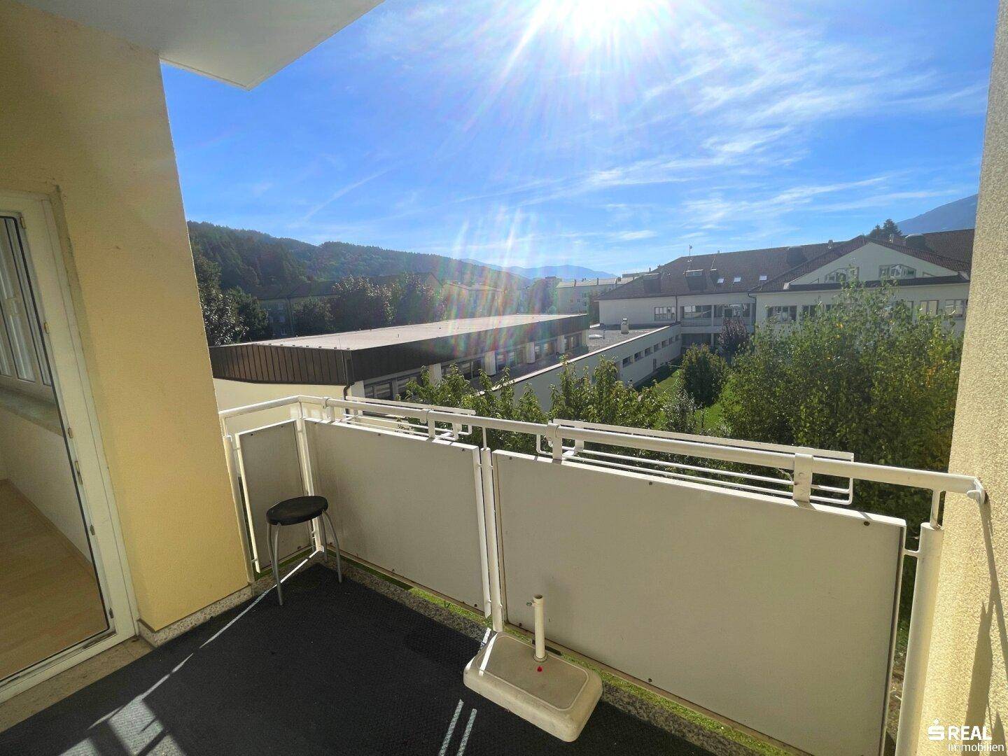 Sonniger Balkon mit weitem Blick auf die umliegende Landschaft und Berge.