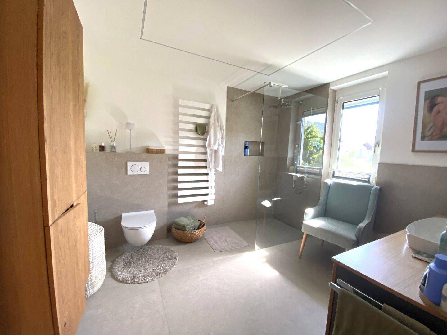 Helles und geräumiges Badezimmer mit großer Dusche, Holzmöbeln und Fenster.