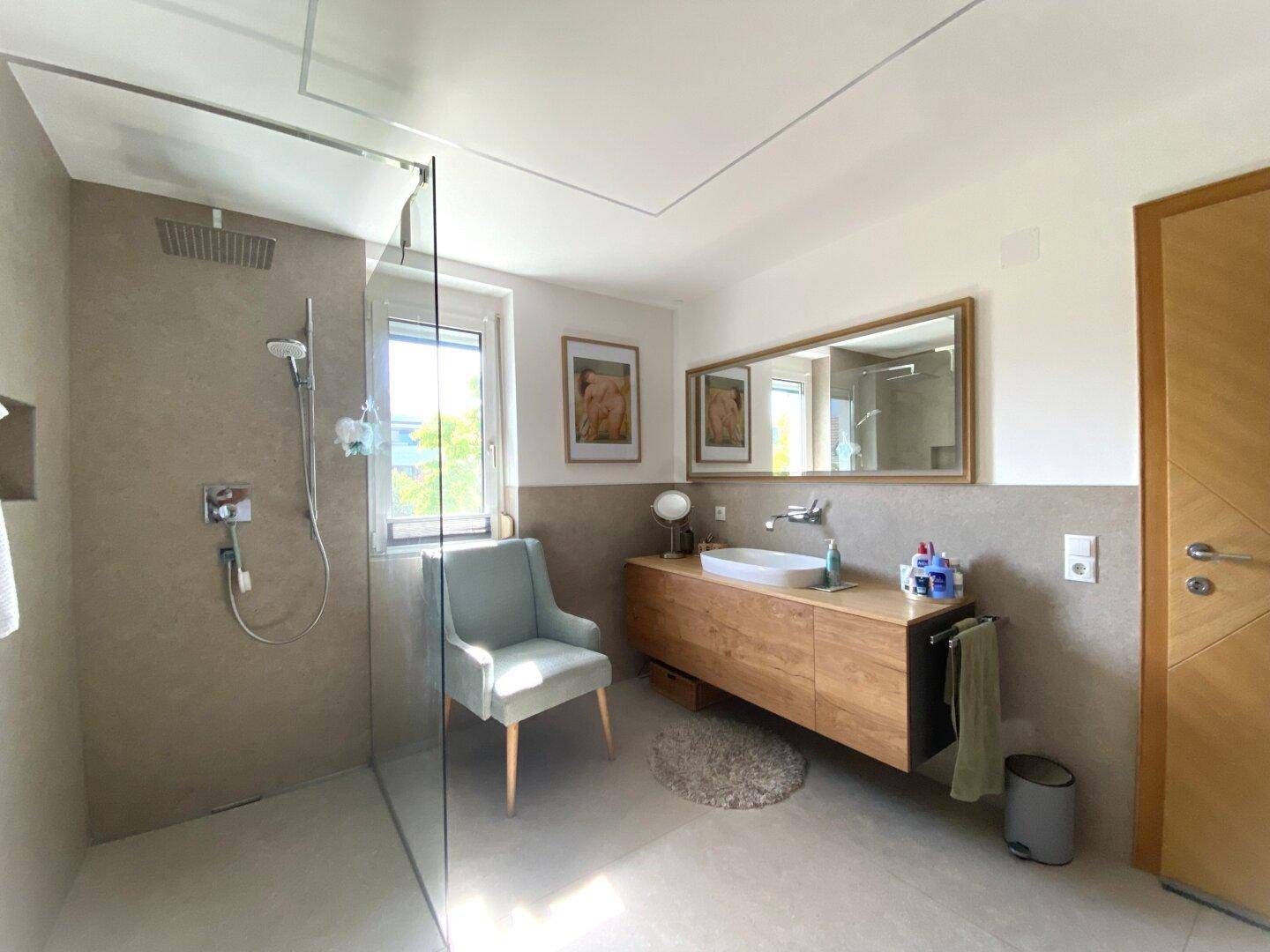 Geräumiges Badezimmer mit ebenerdiger Dusche, Holzwaschtisch und modernem Design.