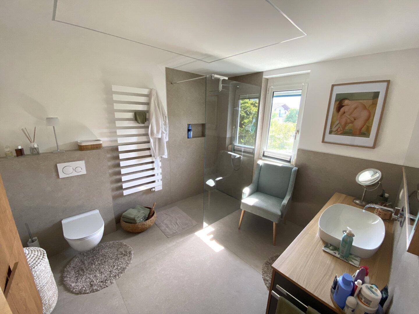 Modernes Badezimmer mit ebenerdiger Dusche, WC, Einzelwaschbecken und Fenster.