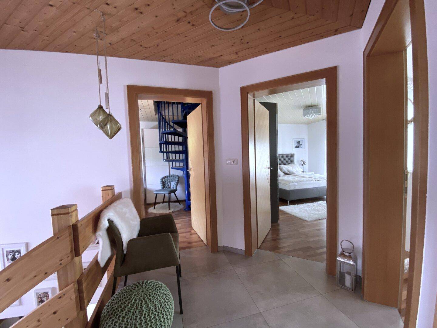 Heller Flur im Obergeschoss mit Holzdecke und Zugang zu den Schlafzimmern.