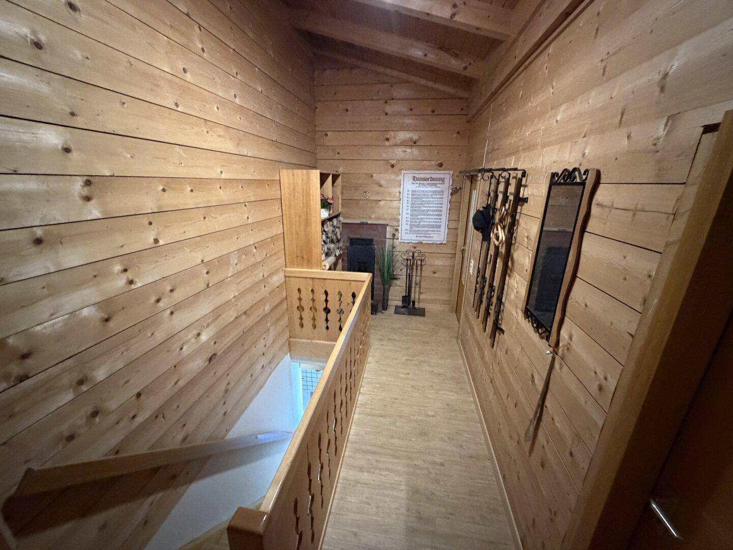 Rustikaler Holzflur mit Treppe, komplett mit Holz verkleidet, strahlt Gemütlichkeit aus.