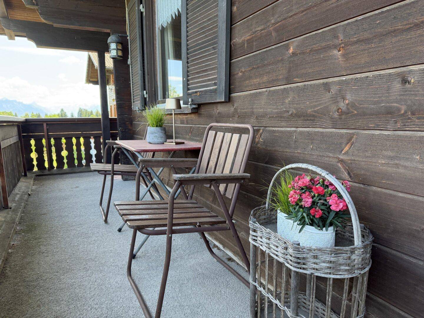 Gemütlicher Balkon mit Gartenmöbeln und Blumen, ideal zum Entspannen im Freien.