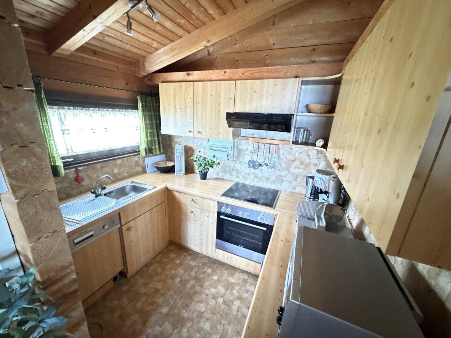 Voll ausgestattete Holzküche mit integrierten Geräten und viel Stauraum.