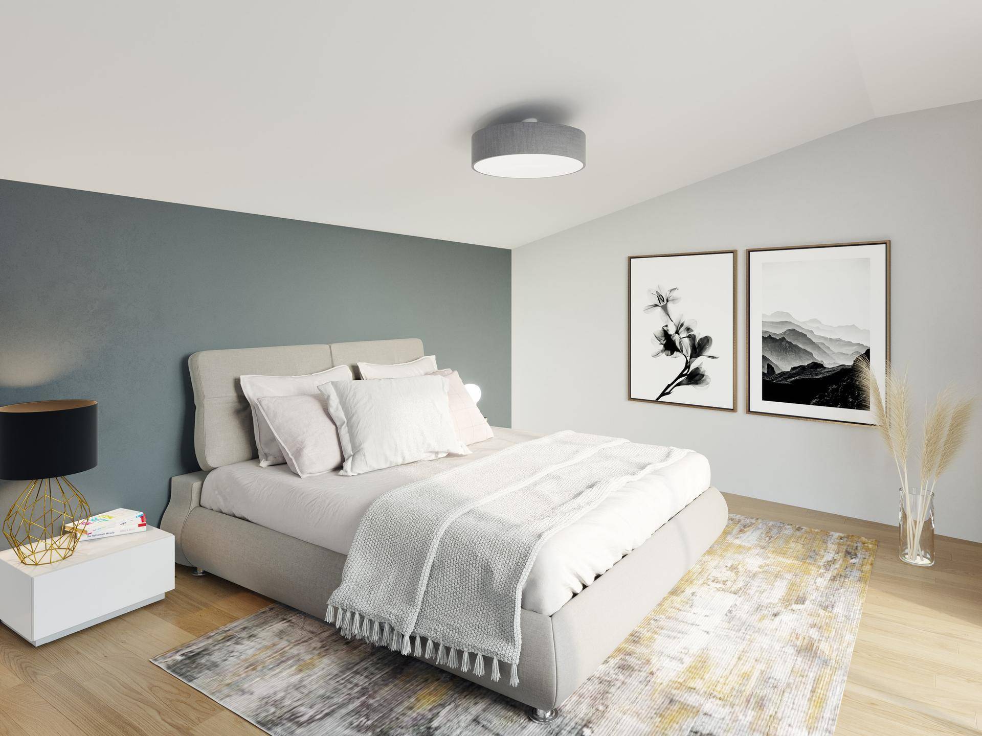 Modernes Schlafzimmer mit beigem Bett, Holzboden und einer Akzentwand in Petrol.
