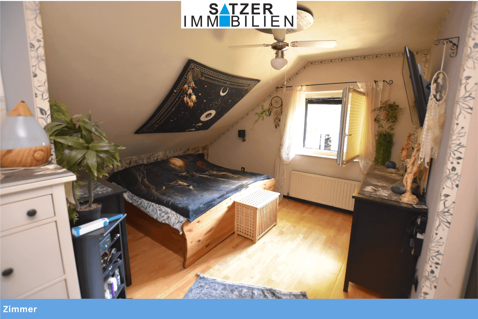 Schlafzimmer im Dachgeschoss mit Holzbett, schräger Decke und Fenster für natürliches Licht.
