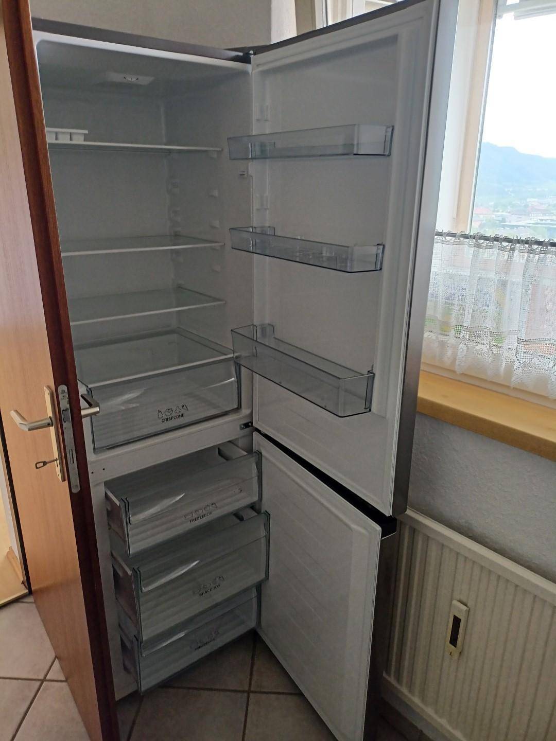 Geräumiger Kühlschrank mit Gefrierfächern, neben einem Fenster in der Küche platziert.