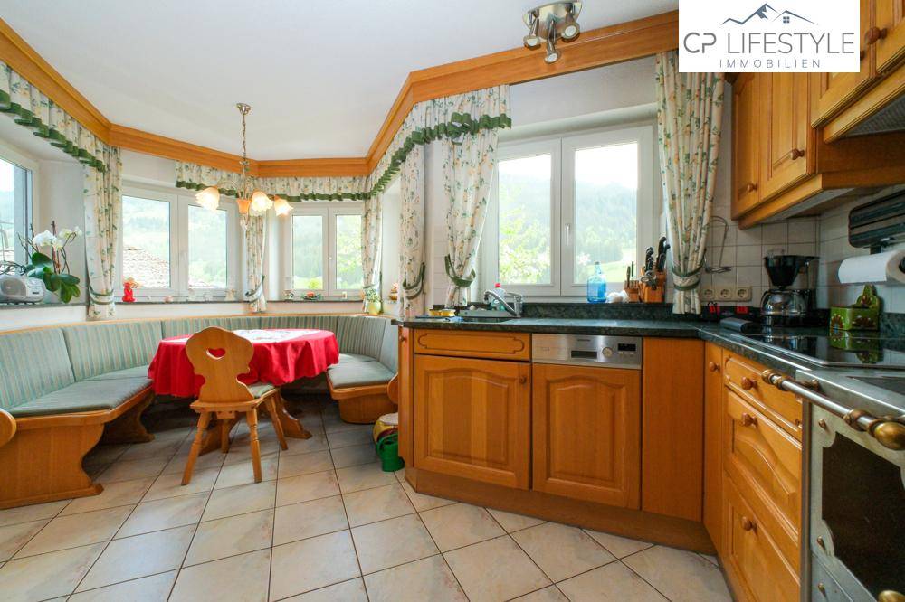 Gemütliche Küche im Landhausstil mit Eckbank, Holzelementen und Bergblick.