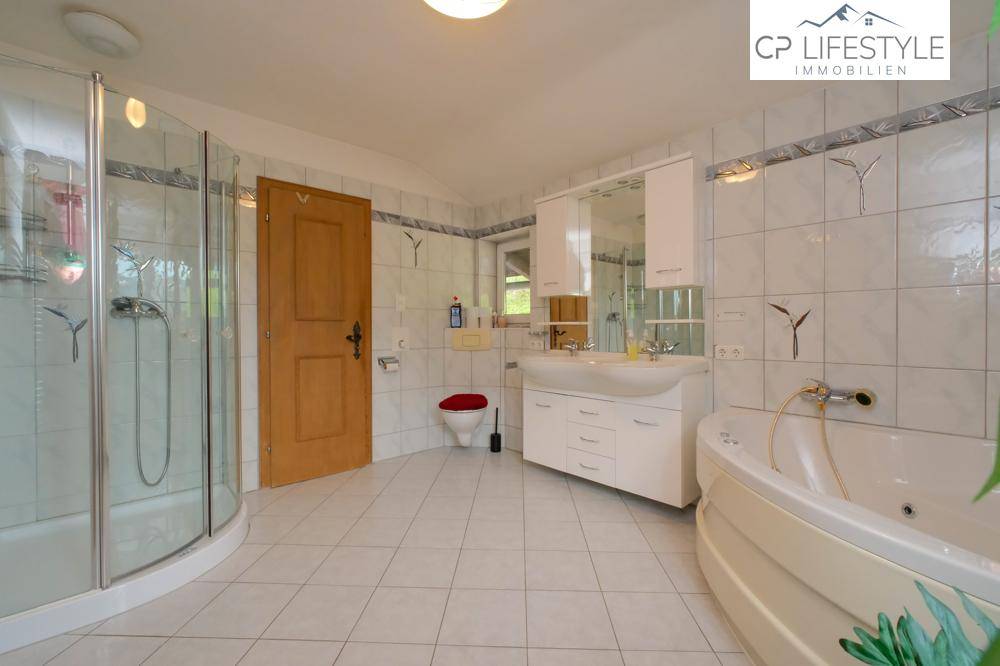 Geräumiges Badezimmer mit Eckbadewanne, Dusche und weißen Fliesen.