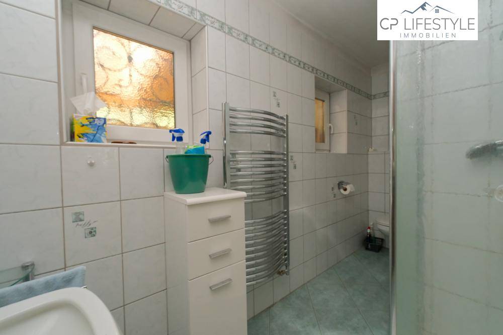 Kleines Badezimmer mit Dusche, beheiztem Handtuchhalter und Fenster.