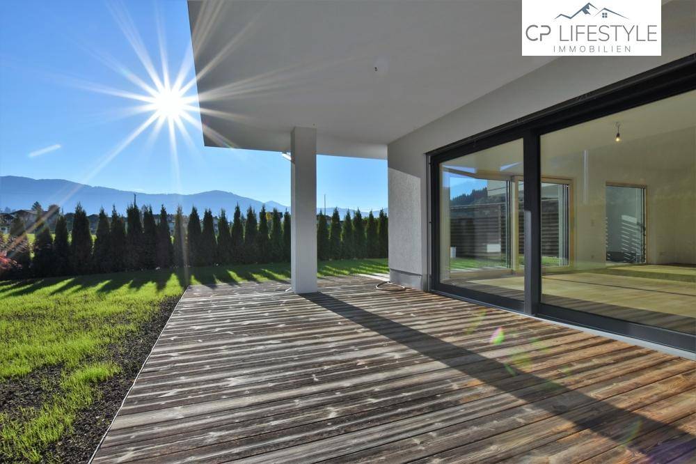 Große Holzterrasse mit Bergblick und viel Sonnenschein, ideal für Entspannung im Freien.